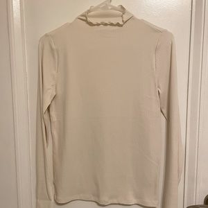 Cream, ribbed, ruffle accent turtleneck. Never worn!